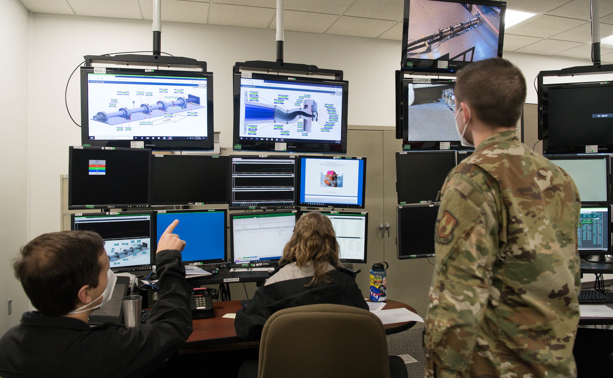 Arnold Engineering Development Complex test engineers, from left, Yancee Burchett, Jillian Sears and Capt. Brian Gatzke, monitor a nozzle test in the Sea Level 2 Test Cell, Dec. 17, 2020, at Arnold Air Force Base, Tenn. The test team was using small-scale models of nozzles to investigate their acoustic properties. (U.S. Air Force photo by Jill Pickett)