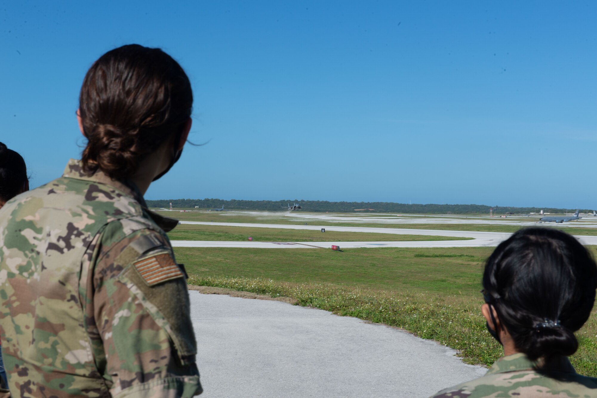 Two Airmen assigned to the 36th Contingency response Group watch a F-16J Eagel take off for Exercise Cope North 2021 at Andersen Air Force Base, Guam, Feb. 10, 2021.