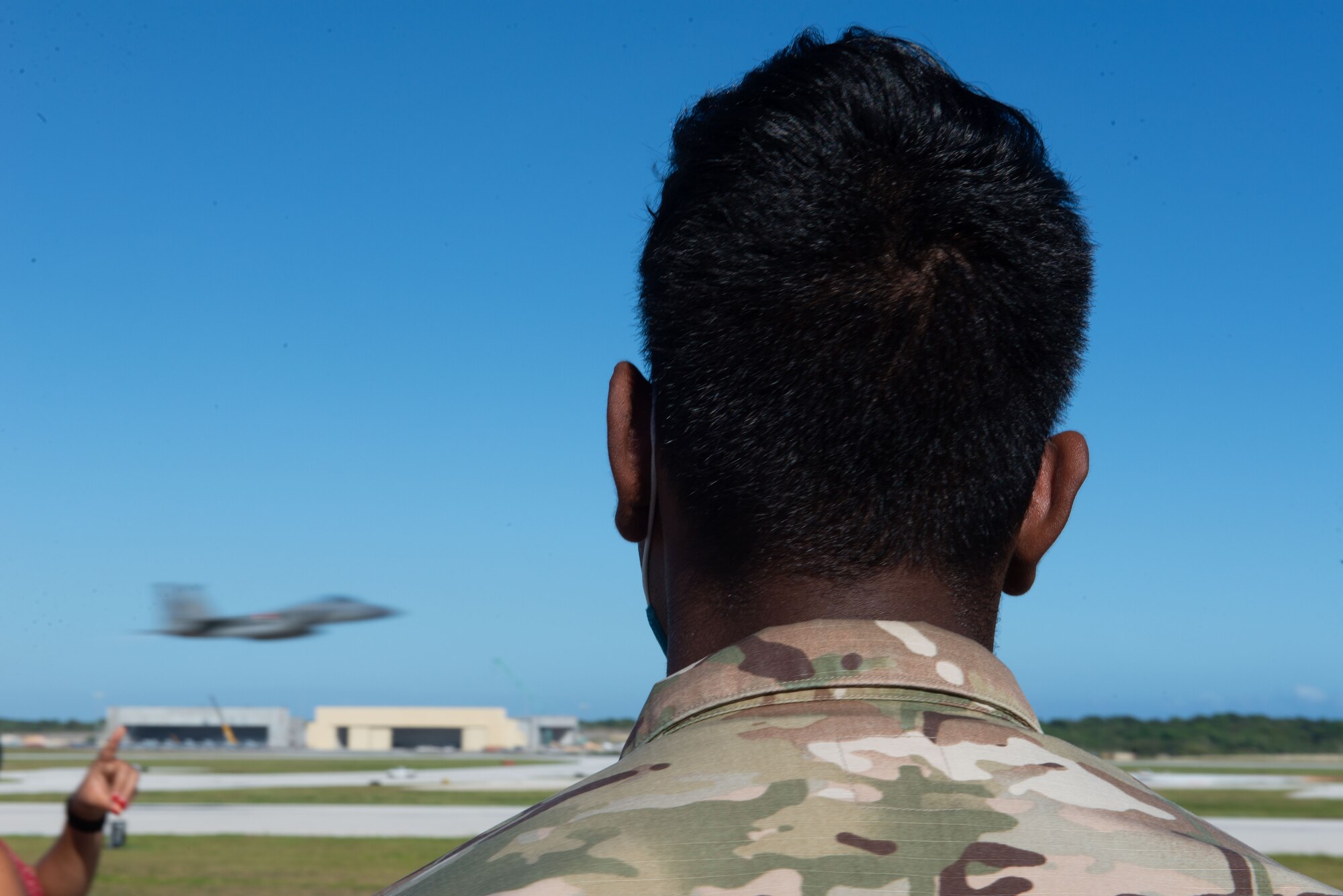 Senior Airmen Navneel Dutt, 644th Combat Communications Squadron, watch a F-15J Eagle speed by during Exercise Cope North 2021 at Andersen Air Force Base, Guam, Feb. 10, 2021.