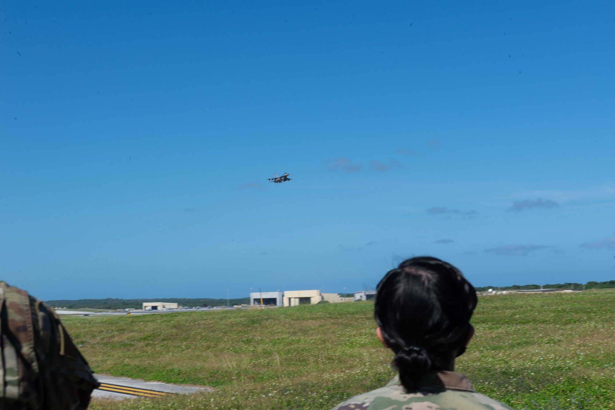 Airmen assigned to the 36th Contingency Response Group watch as a U.S. Air Force F-16 Fighting Falcon, assigned to the 18th Aggressor Squadron, Eielson Air Force Base, Alaska, takes off during a group flight line engagement for Exercise Cope North 2021 at Andersen Air Force Base, Guam, Feb. 10, 2021.