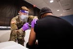 A Soldier administers a COVID-19 vaccine to a local New Jersey citizen in support of COVID-19 vaccine operations.