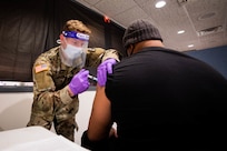 A Soldier administers a COVID-19 vaccine to a local New Jersey citizen in support of COVID-19 vaccine operations.
