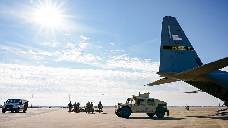 A group of people gather near a plane