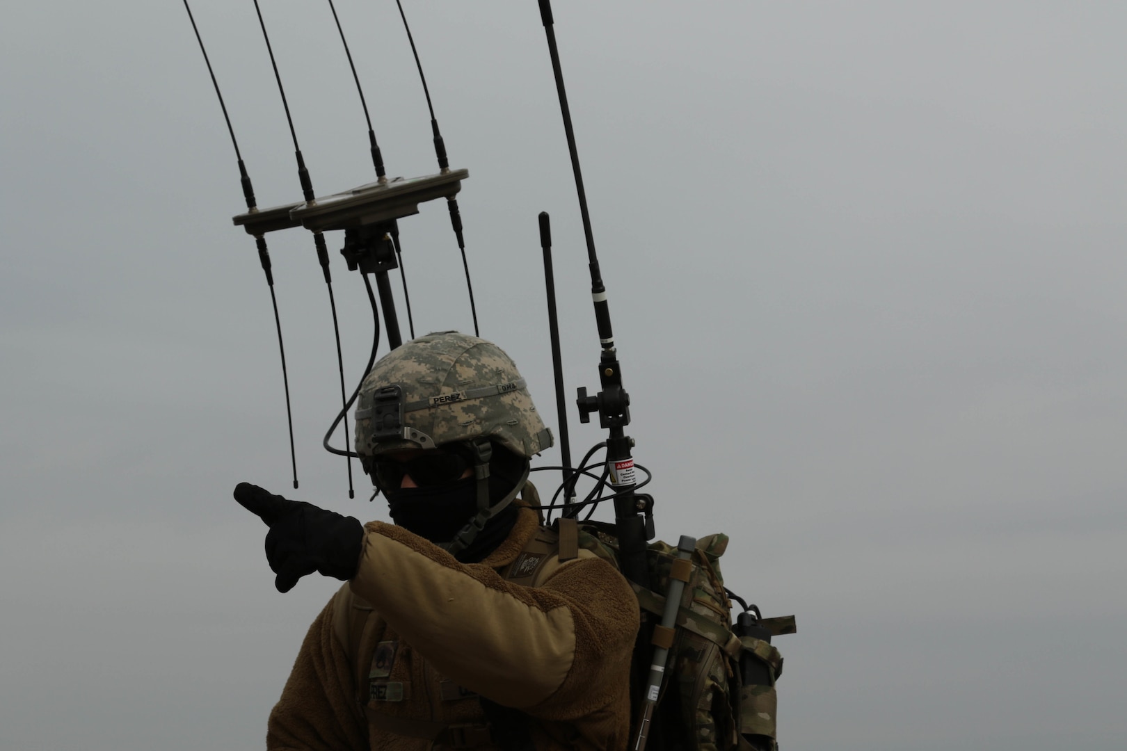 Soldier with Cyber Electromagnetic Activities section, 1st Armored Brigade Combat Team, 1st Infantry Division, points toward nearby objective during final day of training with section’s new electronic warfare equipment, Fort Riley, Kansas, April 6, 2018 (U.S. Army/Michael C. Roach)