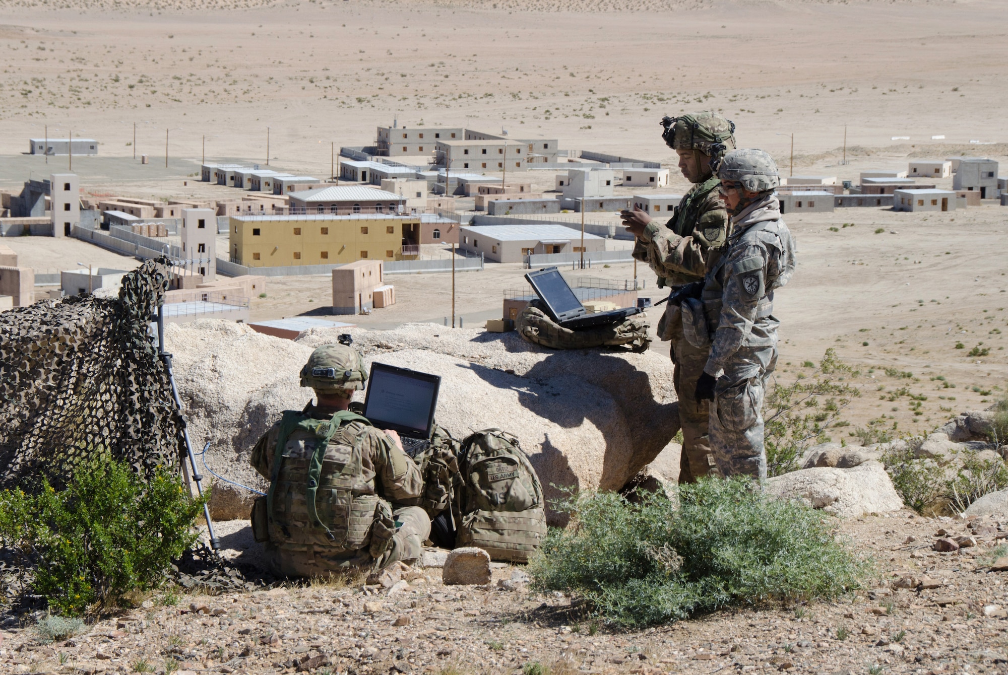 Soldiers of 780th Military Intelligence Brigade set up cyber tools overlooking mock city of Razish at National Training Center, Fort Irwin, California, May 7, 2017 (U.S. Army/Bill Roche)