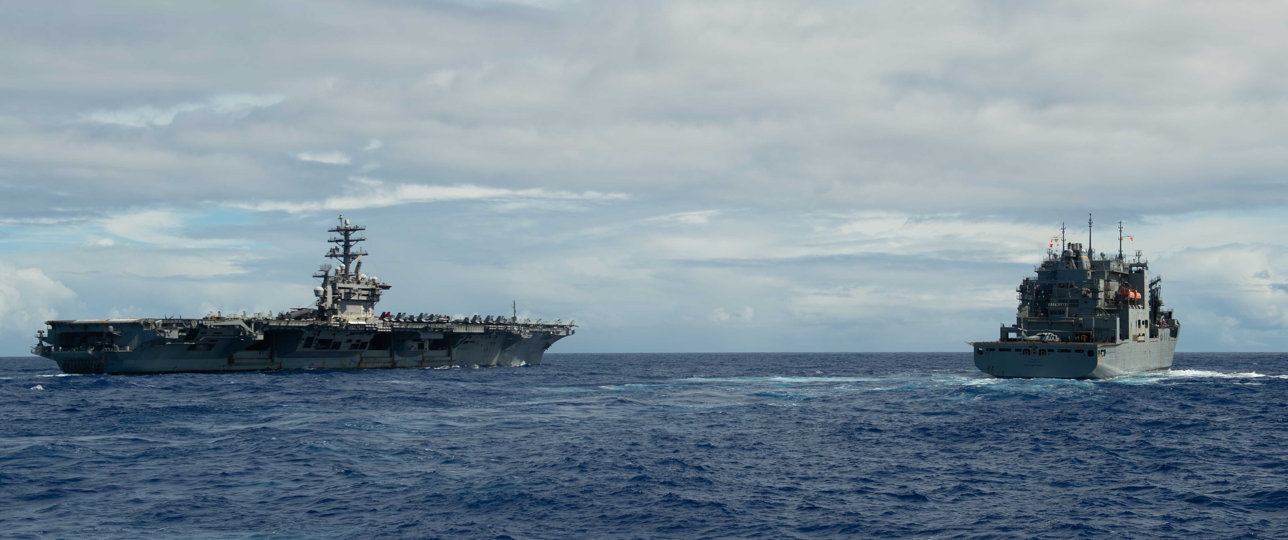 The aircraft carrier USS Nimitz (CVN 68) steams alongside the dry cargo and ammunition ship USNS Matthew Perry (T-AKE 9) following a replenishment-at-sea.