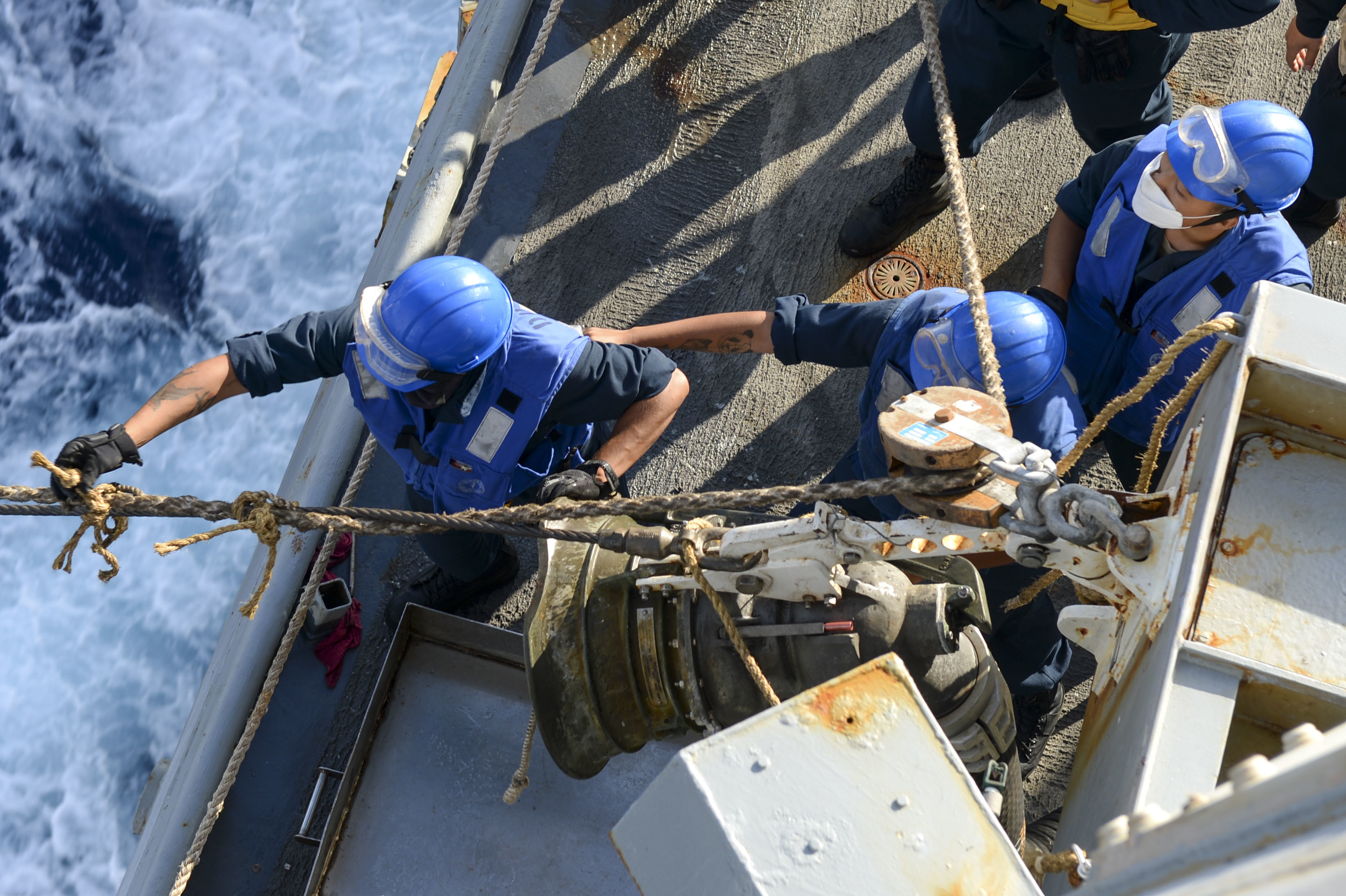 Sailors stabilize a fueling station line aboard USS Russell (DDG 59) during a replenishment-at-sea with USNS Yukon (T-AO 202) Feb. 10, 2021.