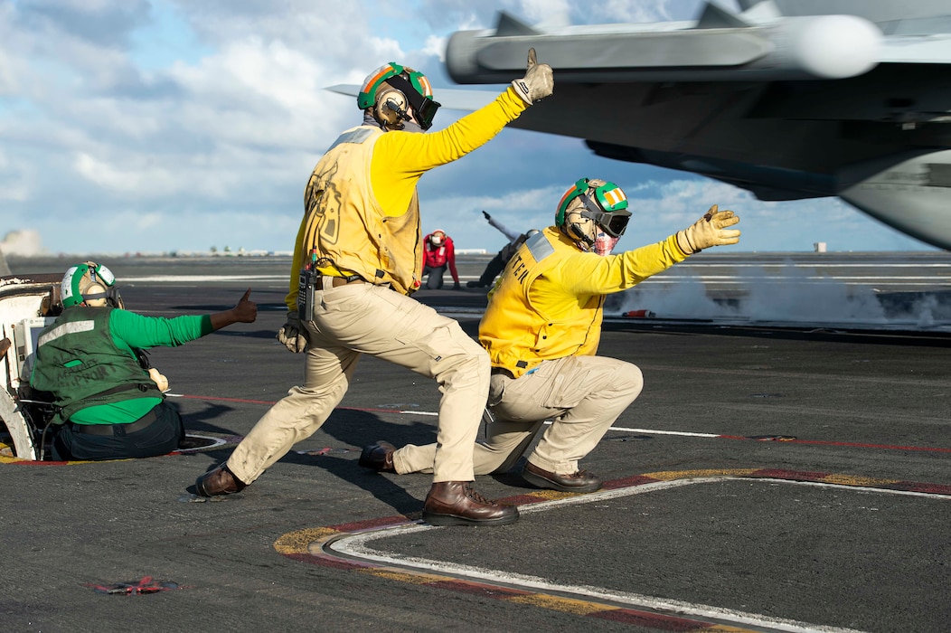 Aviation Boatswain's Mate (Equipment) 3rd Class O'Shea Peck, left, from Winston Salem, N.C., Lt. Kevin Pitcock, center, from Lilburn, Ga., and Lt. Aaron Wanner, from Ossian, Ind., launch an F/A-18E Super Hornet, attached to the "Wildcats" of Strike Fighter Squadron (VFA) 131, from the flight deck aboard the Nimitz-class aircraft carrier USS Dwight D. Eisenhower (CVN 69).