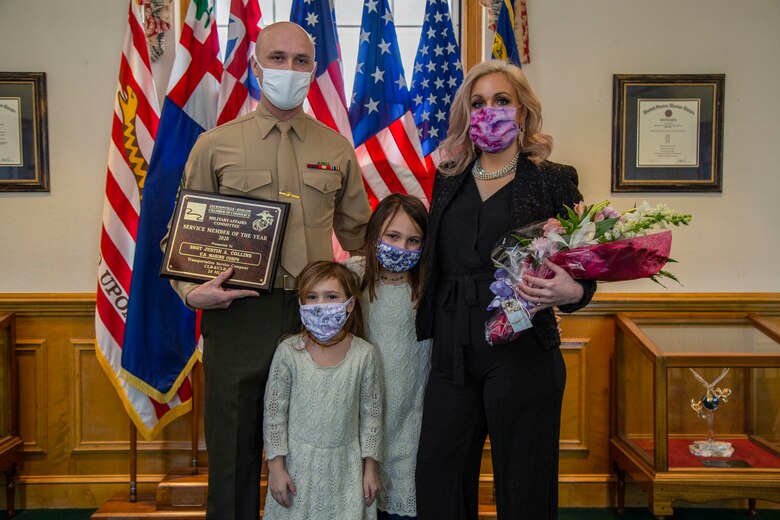 U.S. Marine Corps Staff Sgt. Justin A. Collins, a motor vehicle operator with Combat Logistics Battalion 8, Combat Logistics Regiment 2, 2nd Marine Logistics Group, poses for a photo with his family following a recognition ceremony in his honor as the 2020 Service Member of the Year at building 1 on Marine Corps Base Camp Lejeune, North Carolina, Feb. 8, 2021. The Jacksonville-Onslow Chamber of Commerce, Military Affairs Committee, recognized Collins for his outstanding performance and dedication. (U.S. Marine Corps photo by Cpl. Karina Lopezmata)