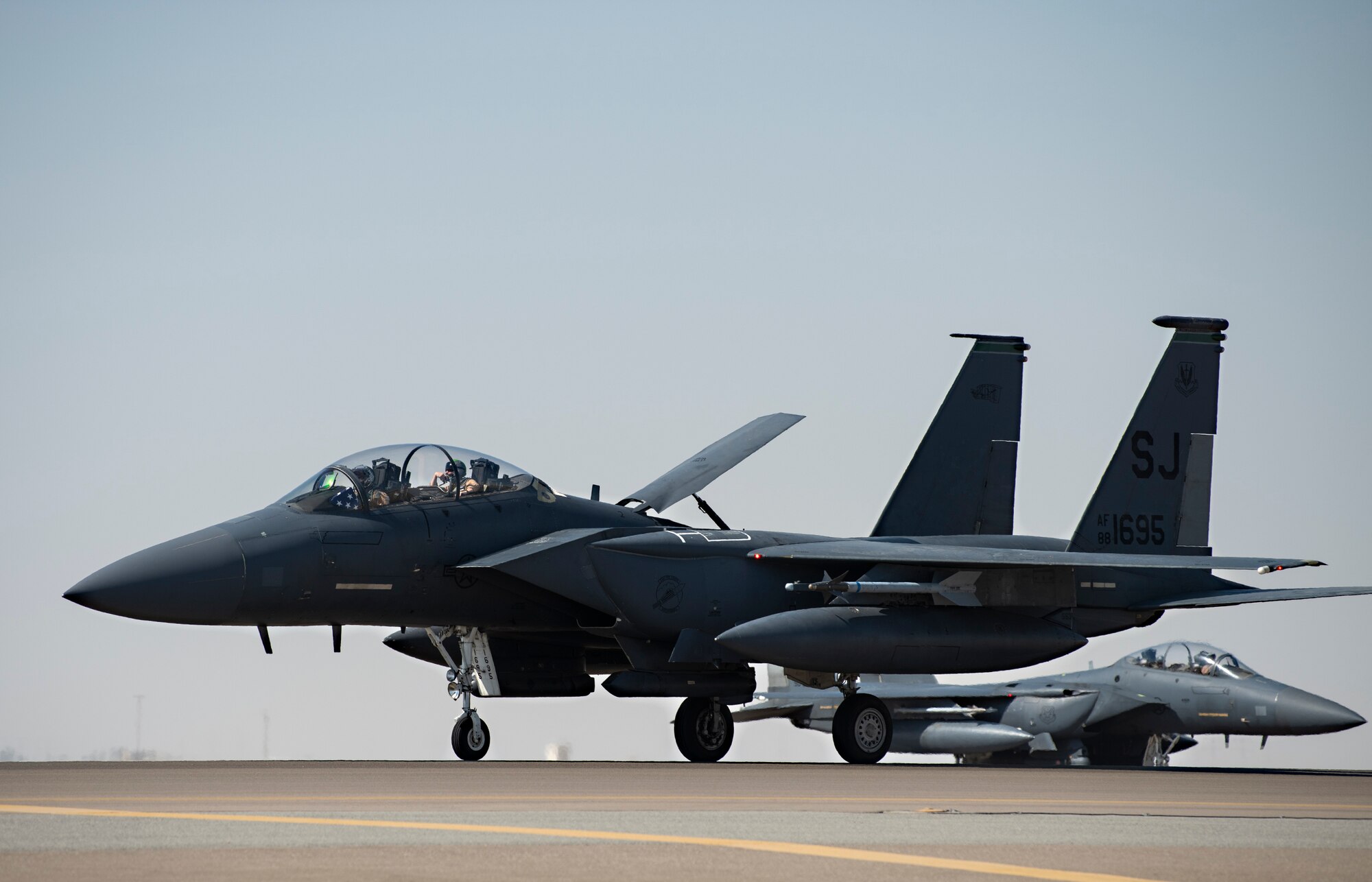 Two U.S. Air Force F-15E Strike Eagles assigned to the 335th Expeditionary Fighter Squadron (EFS) taxi at Al Dhafra Air Base, United Arab Emirates, Feb. 5, 2021.