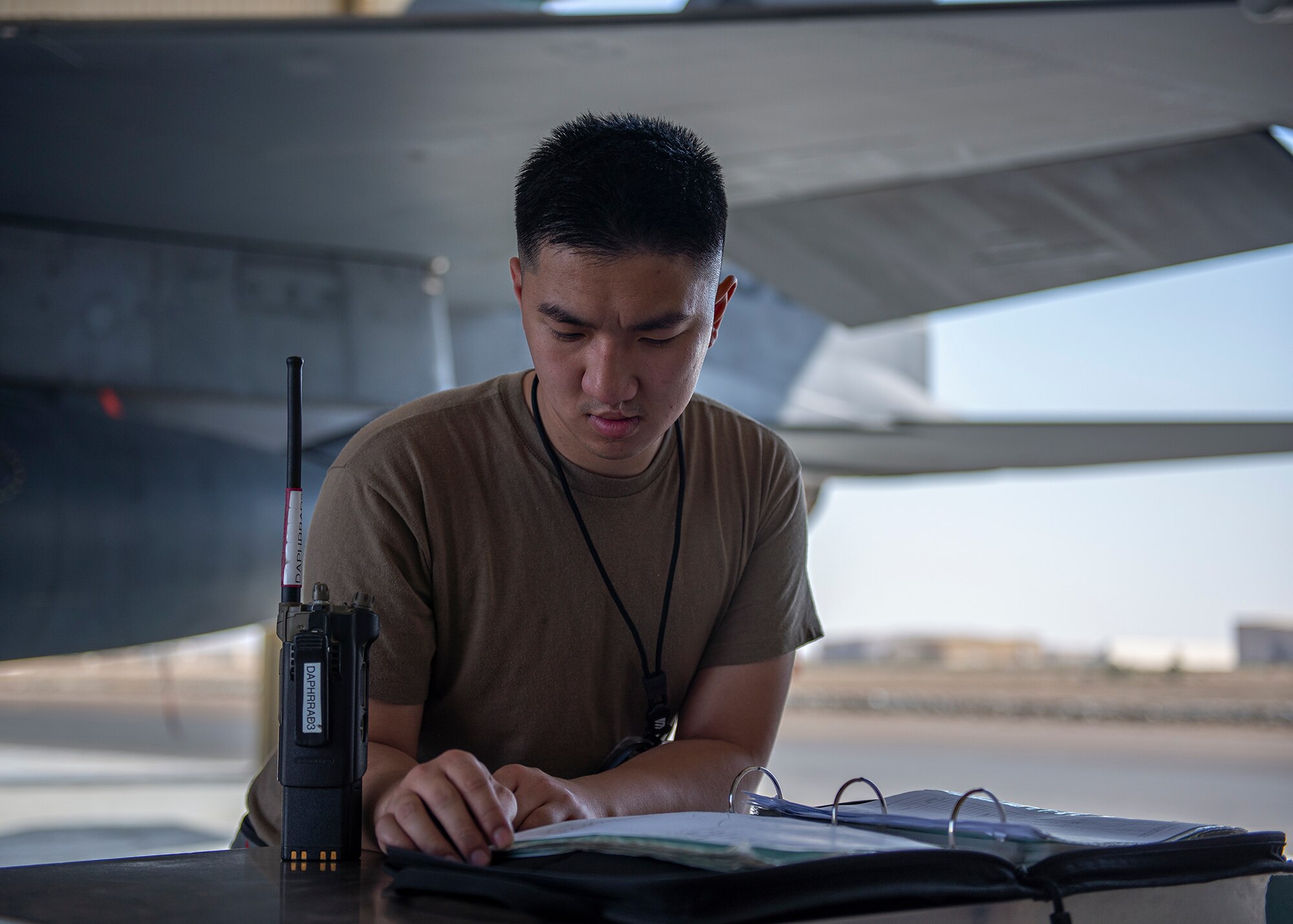 U.S. Air Force Senior Airman James Dang, 380th Expeditionary Aircraft Maintenance Squadron phase inspection journeyman, looks over maintenance logs at Al Dhafra Air Base, United Arab Emirates, Feb. 12, 2021.