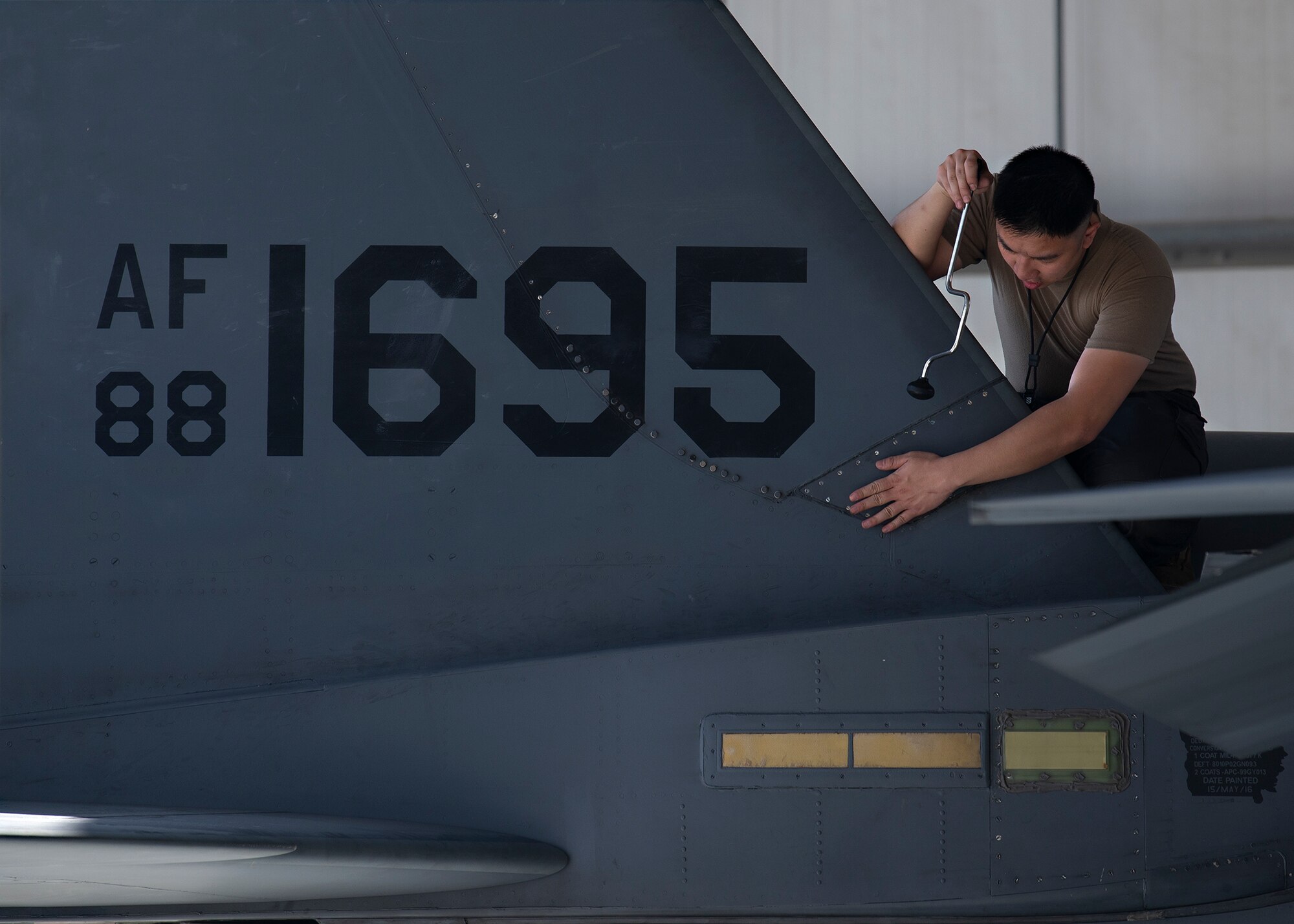 U.S. Air Force Senior Airman James Dang, 380th Expeditionary Aircraft Maintenance Squadron phase inspection journeyman, inspects the tail of an F-15E Strike Eagle at Al Dhafra Air Base, United Arab Emirates, Feb. 12, 2021.
