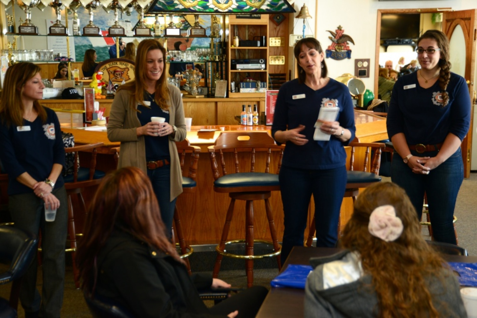 Members of the Guardian Spouses speak with the spouses, or soon-to-be spouses, of graduating recruits from U.S. Coast Guard Training Center Cape May, N.J., Feb. 27, 2015. The Guardian Spouses provide information about military life in a positive and informative way every graduation day. (U.S. Coast Guard photo by Chief Warrant Officer John Edwards)