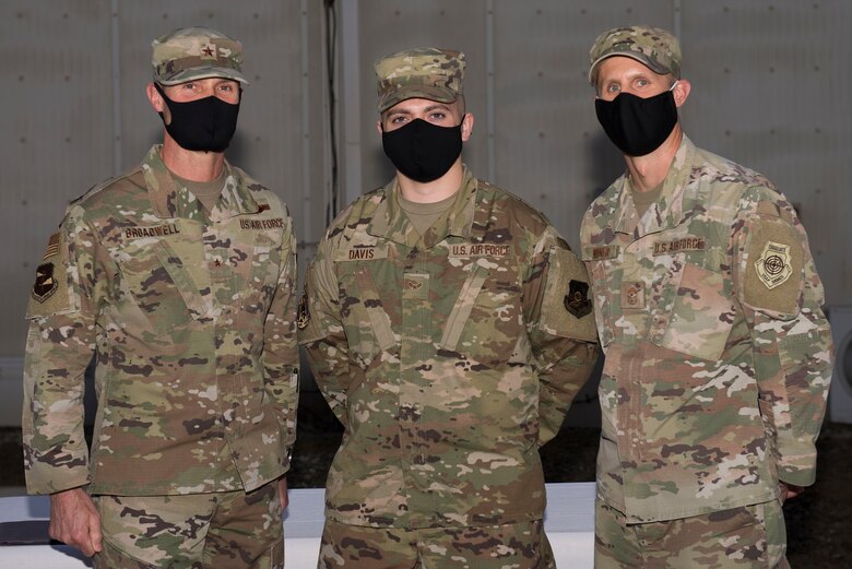 A U.S. Space Force defender assigned to the 380th Air Expeditionary Wing poses with wing leadership following a transfer ceremony at Al Dhafra Air Base, United Arab Emirates, Feb. 12, 2021.