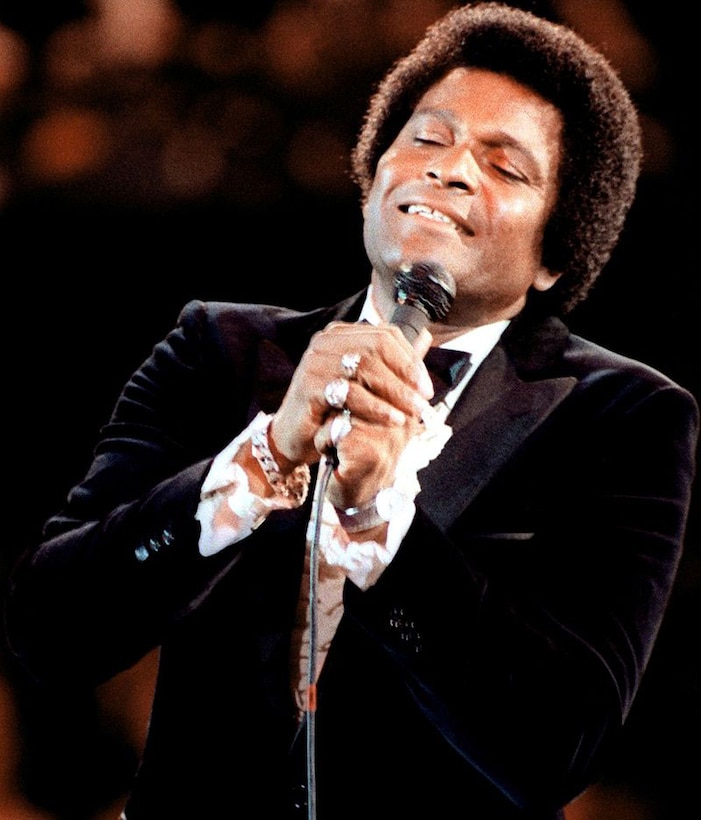 A man in a tuxedo sings into a microphone .