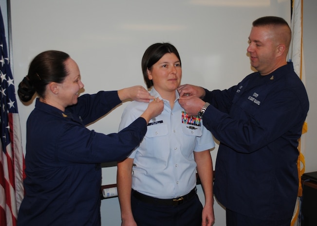 MICHIGAN CITY, Ind. - Senior Chief Petty Officer Colleen McCarthy, (left), officer-in-charge of Coast Guard Station Kenosha, Wis., and Senior Chief Petty Officer Michael Beatty, officer-in-charge of Coast Guard Station Frankfort, Mich., pin new rank insignias on the collar of Rebecca Polzin, officer-in-charge of Coast Guard Station Michigan City during her advancement to senior chief petty officer, Feb. 2, 2012. As officer-in-charge, Polzin ensures the 19 enlisted active duty members and 7 enlisted Coast Guard reservists at Station Michigan City carry out their missions of search and rescue; maritime law enforcement; ports, waterways, and coastal security; and marine environmental protection. U.S. Coast Guard photo by Seaman Kody Felthoff.