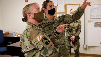 Lt. Col. Traci Earls, commander of the 169th Combat Sustainment Support Battalion, 69th Troop Command, Kansas Army National Guard, left, is briefed on a COVID-19 mitigation mission by Capt. Kelsie Knudson, West Bliss officer in charge, at Fort Bliss, Texas, Jan. 27, 2021. The unit, which had planned to deploy to Afghanistan in July 2020, was reassigned to run sustainment operations for COVID-19 mitigation procedures for Soldiers mobilizing to and demobilizing from overseas.