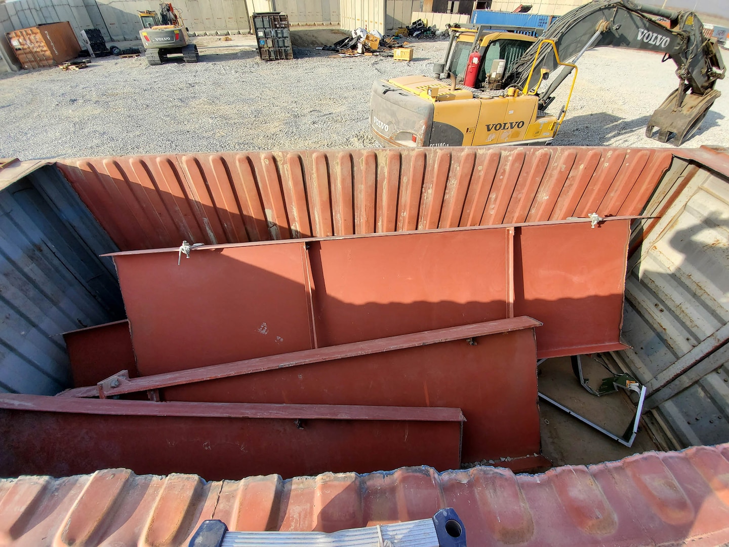 Pieces of excess building materials processed at the DLA Disposition Services site at Bagram, Afghanistan, are placed into a container for sale as scrap metal.