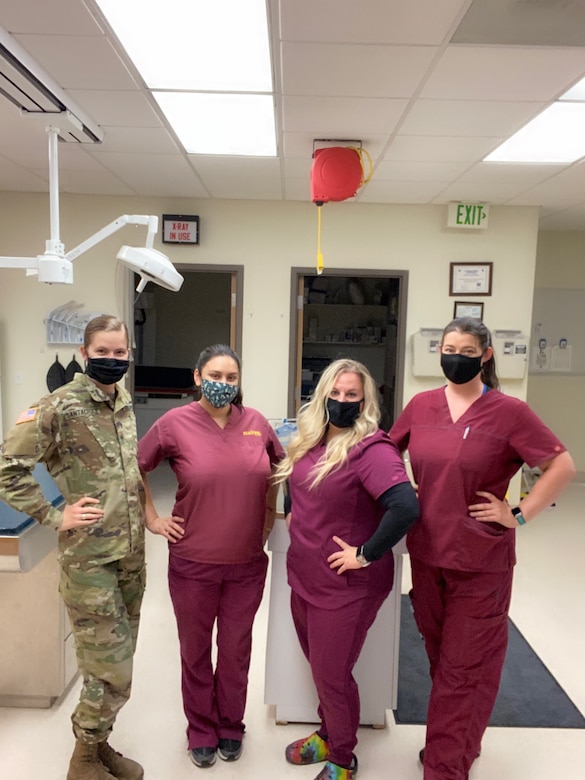 Sgt. Ashley Santacroce, noncommissioned officer in charge of Miramar Veterinary Treatment Facility and an animal care specialist, Spc. Jessica Bonner, a veterinary food inspection specialist, Krystal Lester and Emily Jackson, both nonappropriated fund veterinary technicians, stand together at the Miramar VTF, Calif., Oct. 2020. The staff at the VTF is responsible for the care of more than 7,100 animal patients. (Courtesy photo)