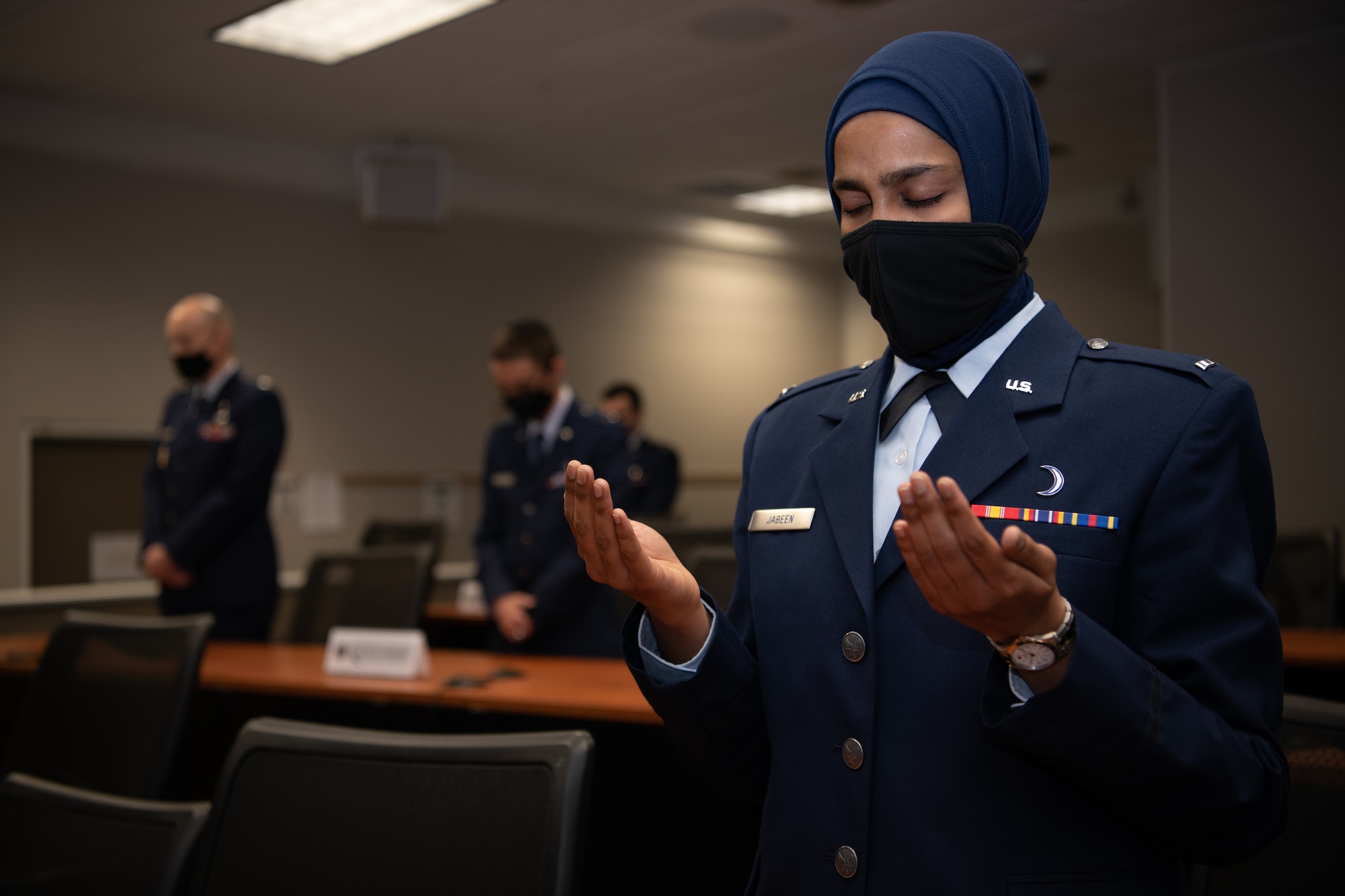 First Lt. Saleha Jabeen, a graduate of Basic Chaplain Course Class 21A, raises her hands in prayer during a group prayer at the start of the graduation ceremony Feb. 5, 2021, at the Ira C. Eaker Center for Leadership Development on Maxwell Air Force Base, Ala. Jabeen, a native of India, is the first female Muslim chaplain to serve in the U.S. military.