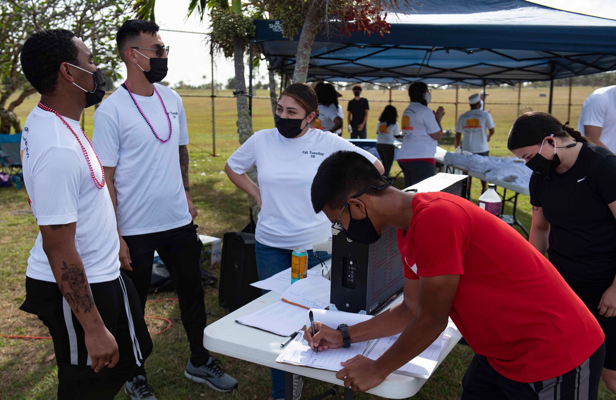 Volunteers help sign people in for the first ever Fat Tuesday 5K fun run at Andersen Air Force Base, Guam, Feb. 16, 2021.