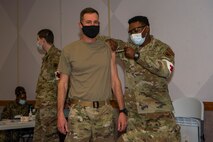 Airman standing receiving a vaccine