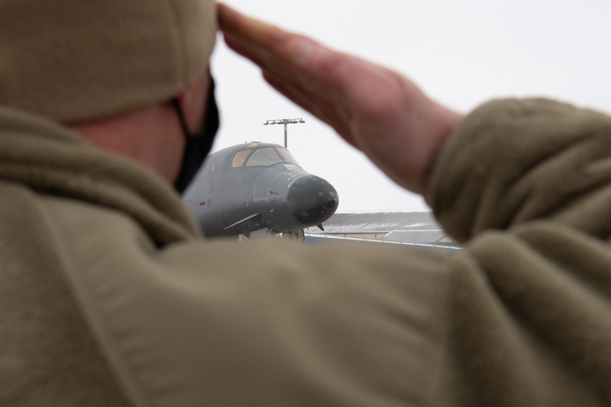 Master Sgt. David Jackson, the 28th Aircraft Maintenance Squadron production superintendent, renders a farewell salute a B-1B Lancer being divested prior to its final departure from Ellsworth Air Force Base, S.D., Feb. 17, 2021. This limited aircraft divestiture will contribute to funding investments in key capabilities for the future bomber force and allow B-1B maintainers to focus their efforts on the healthiest B-1s that remain in the fleet.  (U.S.  Air Force photo by Airman Jonah Fronk)