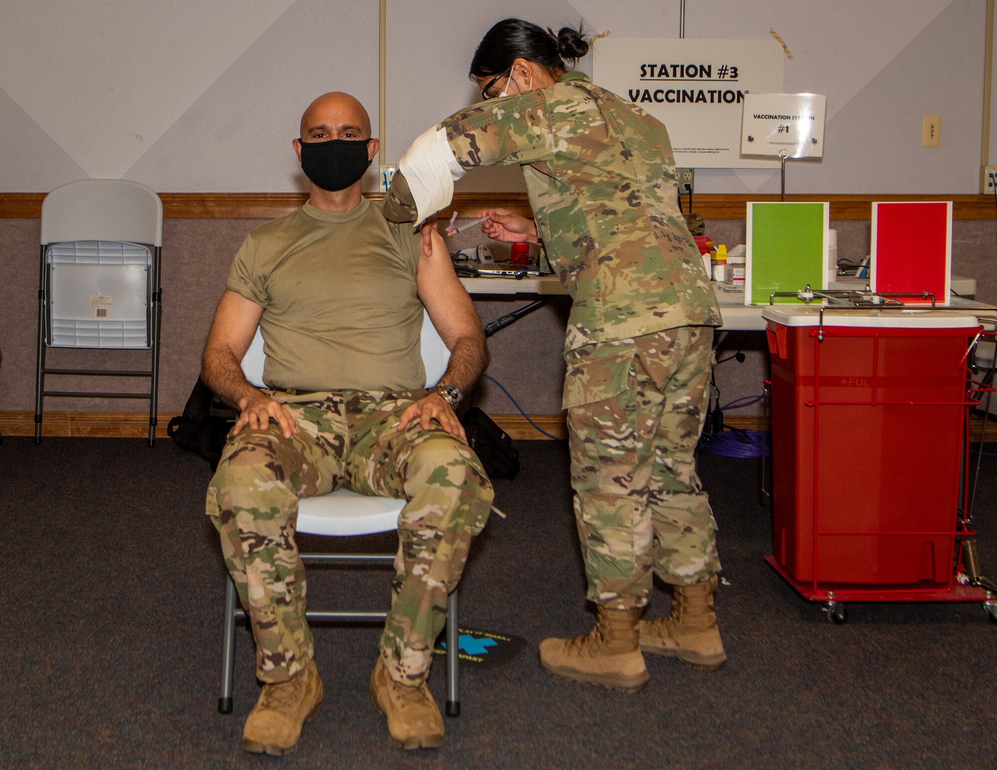 Airman sitting in chair receiving a vaccine