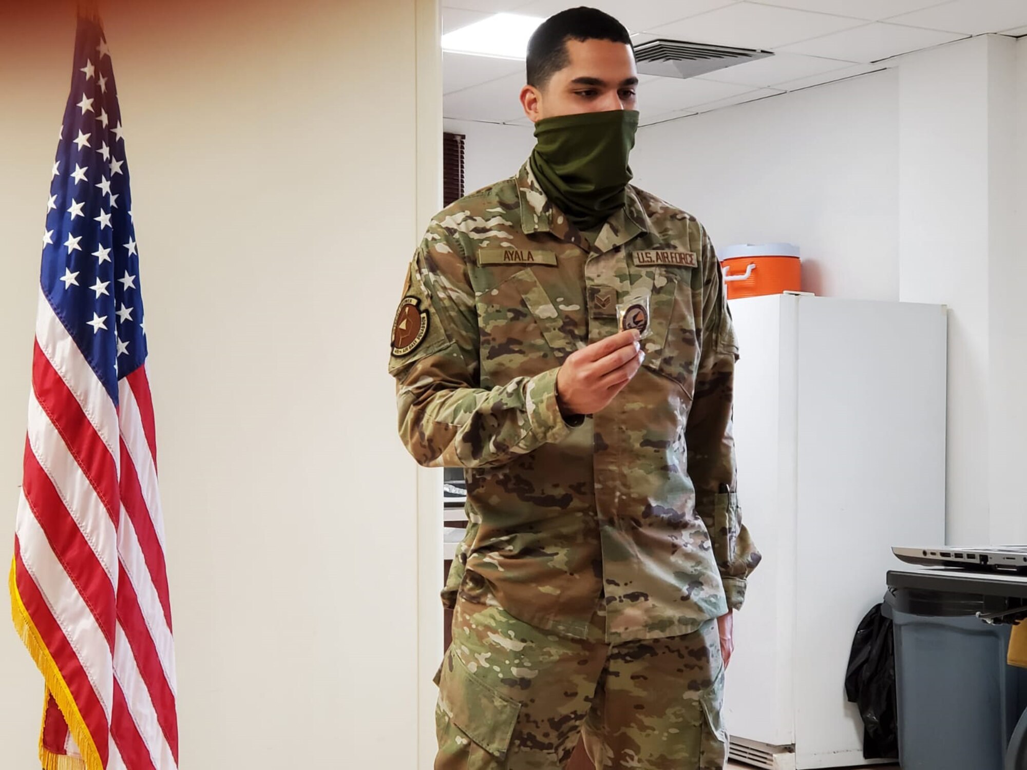 U.S. Air Force Senior Airman Josué Ayala Pérez, 496th Air Base Squadron fuels technician, holds a commander’s coin during an Airlifter of the Week ceremony.