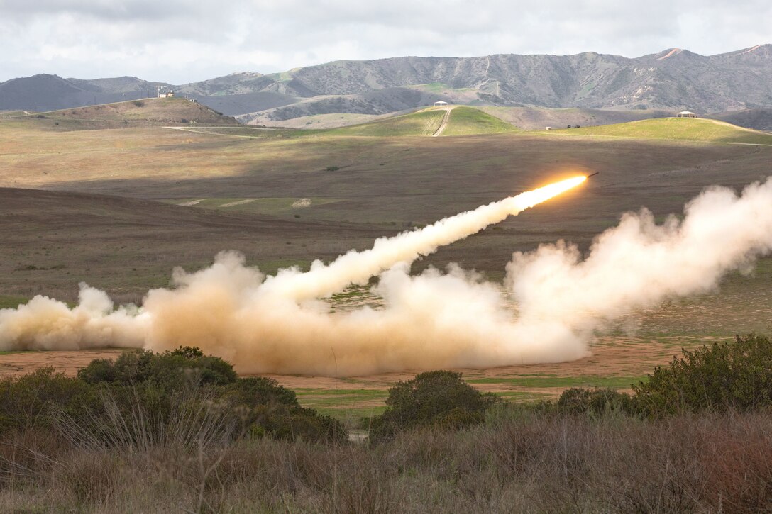 A rocket is fired into the air leaving behind a smoke trail.