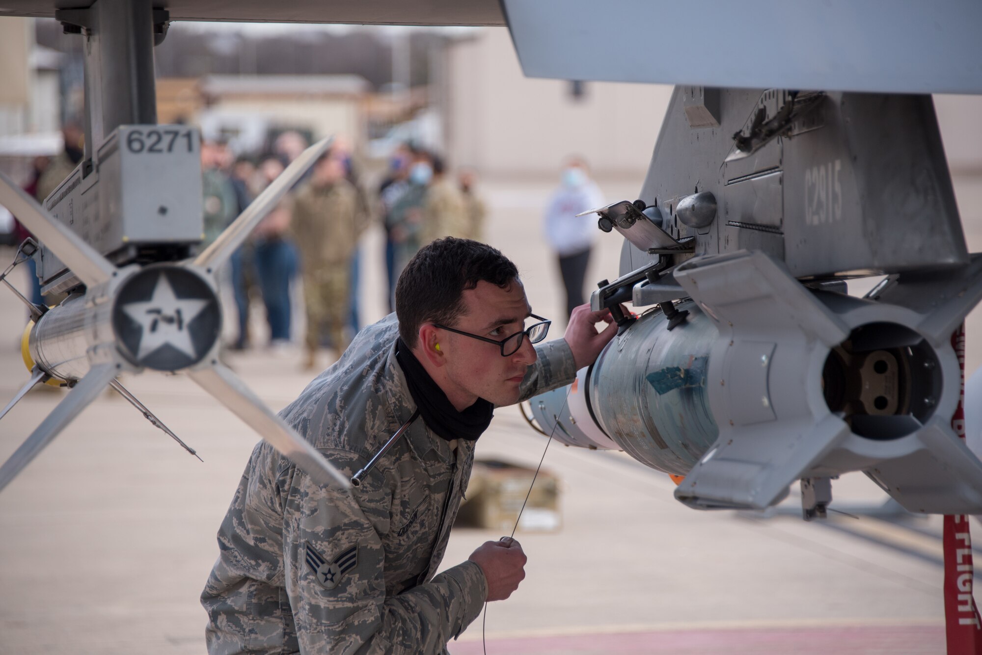 Senior Airman Seon Dodson, 301st Fighter Wing Aircraft Maintenance Squadron weapons load crew member, routes the arming lanyard to the wing release lever of the GBU-12 bomb, attached to the 301st Fighter Wing’s F-16 during a weapons load competition at U.S. Naval Air Station Joint Reserve Base Fort Worth, Texas on February 5, 2021. The competition challenges Reserve Citizen Airmen, improves mission readiness, and highlights the immense amount of training hours that have gone into learning their skillset. (U.S. Air Force photo by Senior Airman William Downs)