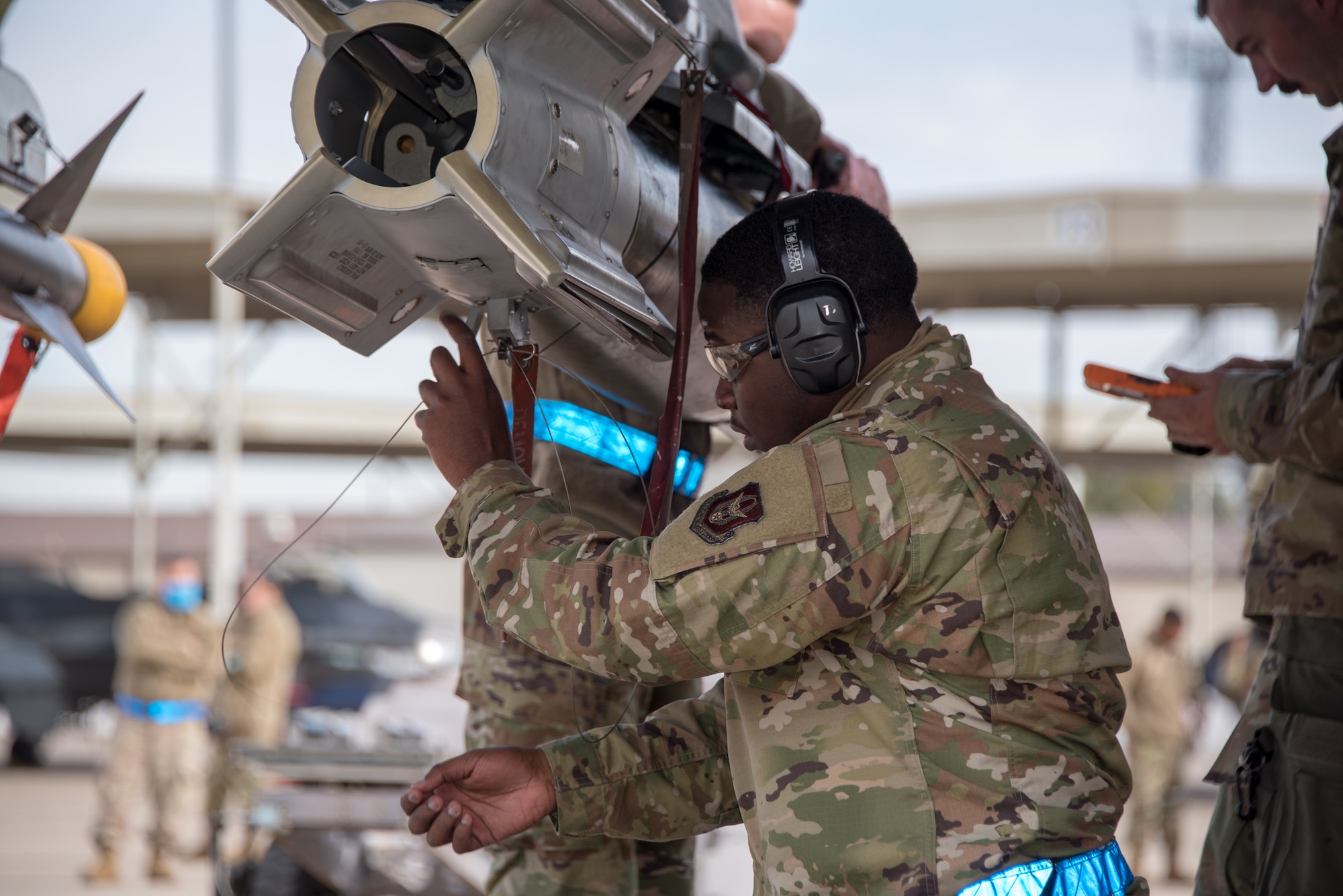 Senior Airman Keyshawn Johnson, 301st Fighter Wing Aircraft Maintenance Squadron weapons load crew member, routes the arming lanyard to the F-16 wing release lever of the GBU-12 bomb during a weaponsload competition at U.S. Naval Air Station Joint Reserve Base Fort Worth, Texas on February 5, 2021. Loading aircraft munitions is how the weapons section fit into the 301 FW mission—to train, deploy, combat ready Airmen. (U.S. Air Force photo by Senior Airman William Downs)