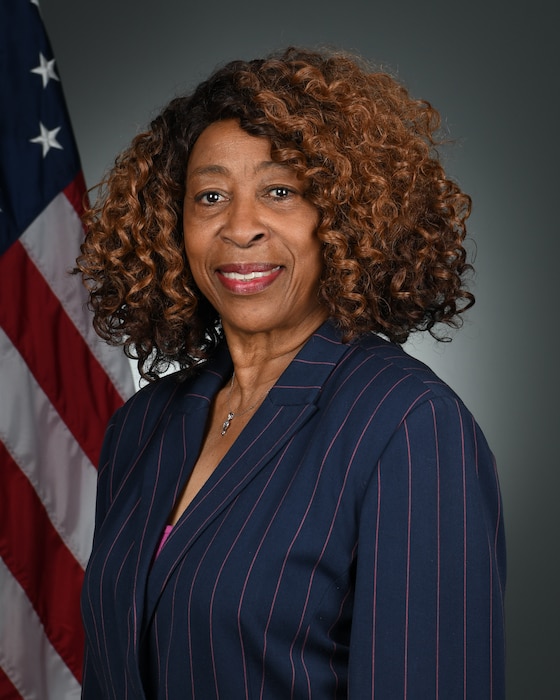 Photo shows woman standing in front of U.S. flag.