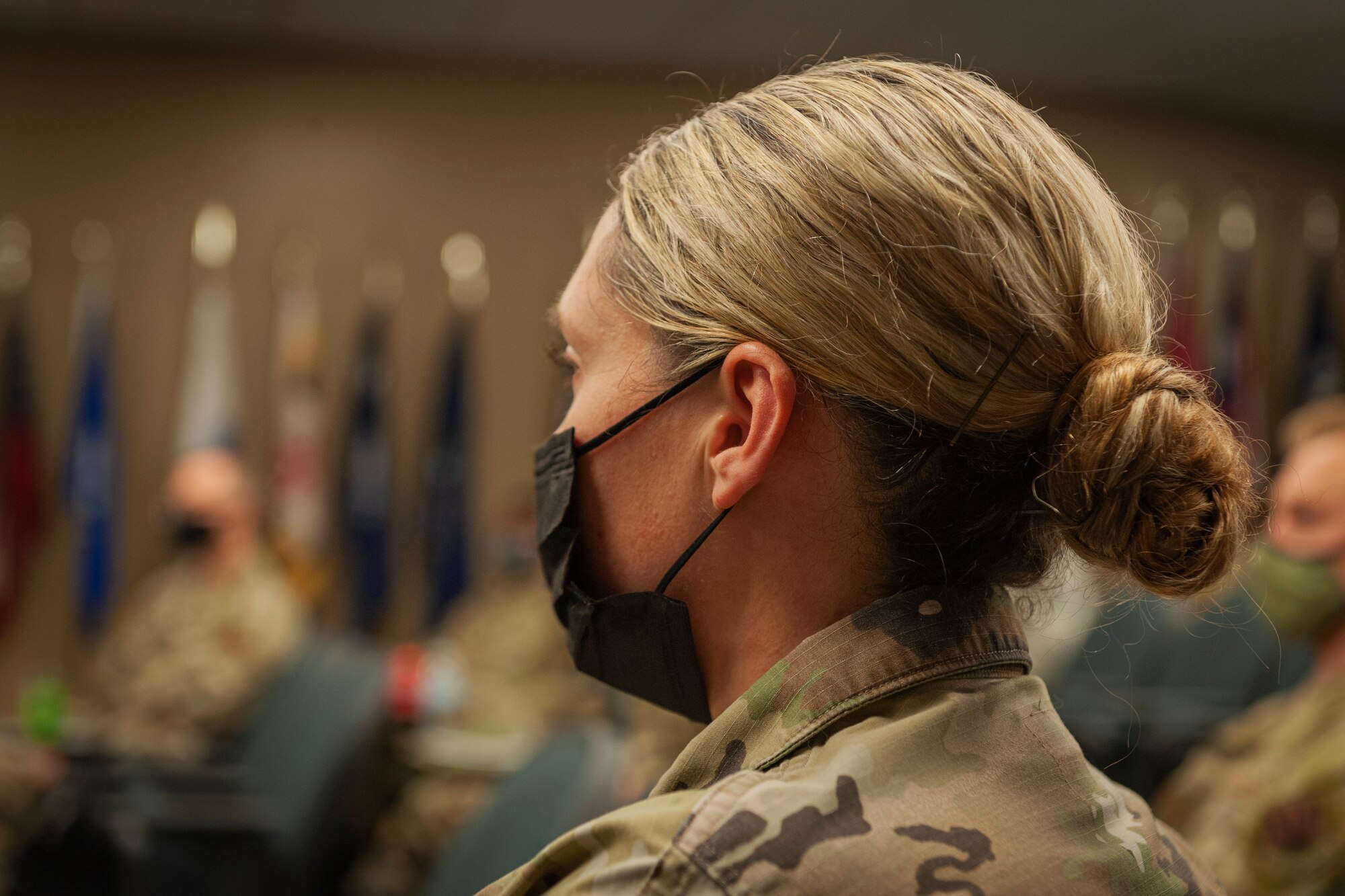 Photo of an Airman listening to chiefs speak