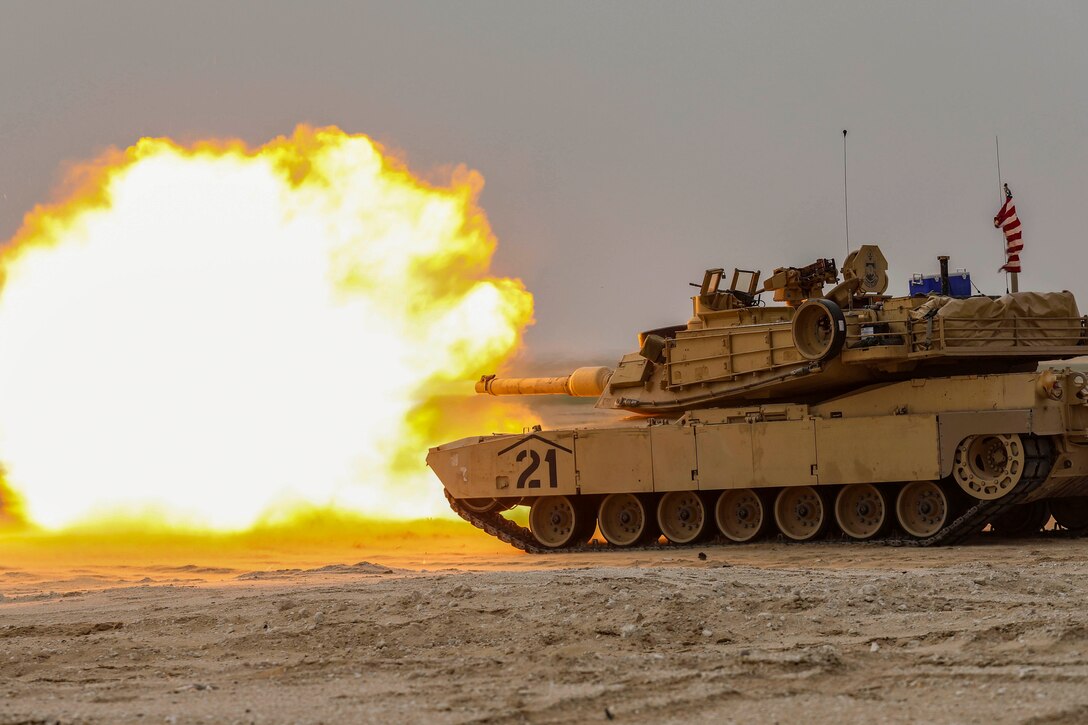 A sailor fires rounds from an Army vehicle.