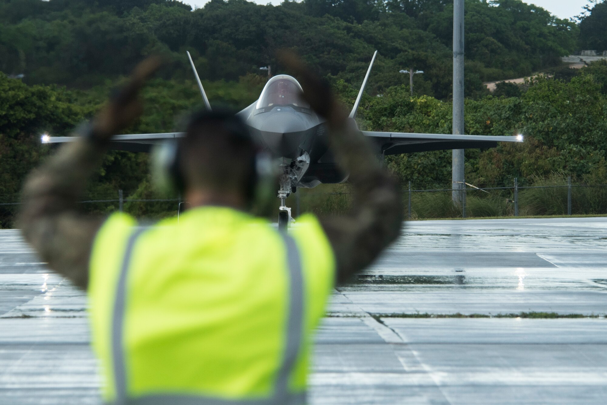 A U.S. Air Force Airman marshalls a U.S. Air Force F-35A Lightning II assigned to Eielson Air Force Base, Alaska, as part of Cope North 21 at Andersen AFB, Guam, Feb. 6, 2021. Cope North is an annual multinational exercise designed to increase capabilities and improve interoperability among partner nations. The F-35As will play a significant role in the exercise’s Agile Combat Employment and combat air forces training scenarios. (U.S. Air Force photo by Senior Airman Jonathan Valdes Montijo)