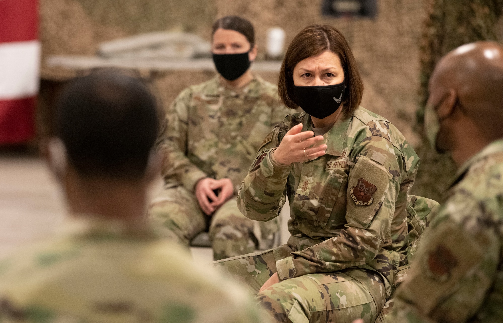 Chief Master Sergeant of the Air Force JoAnne S. Bass sits in a char while gesturing with her hands to Chief Master Sgt. Nathaniel Perry.