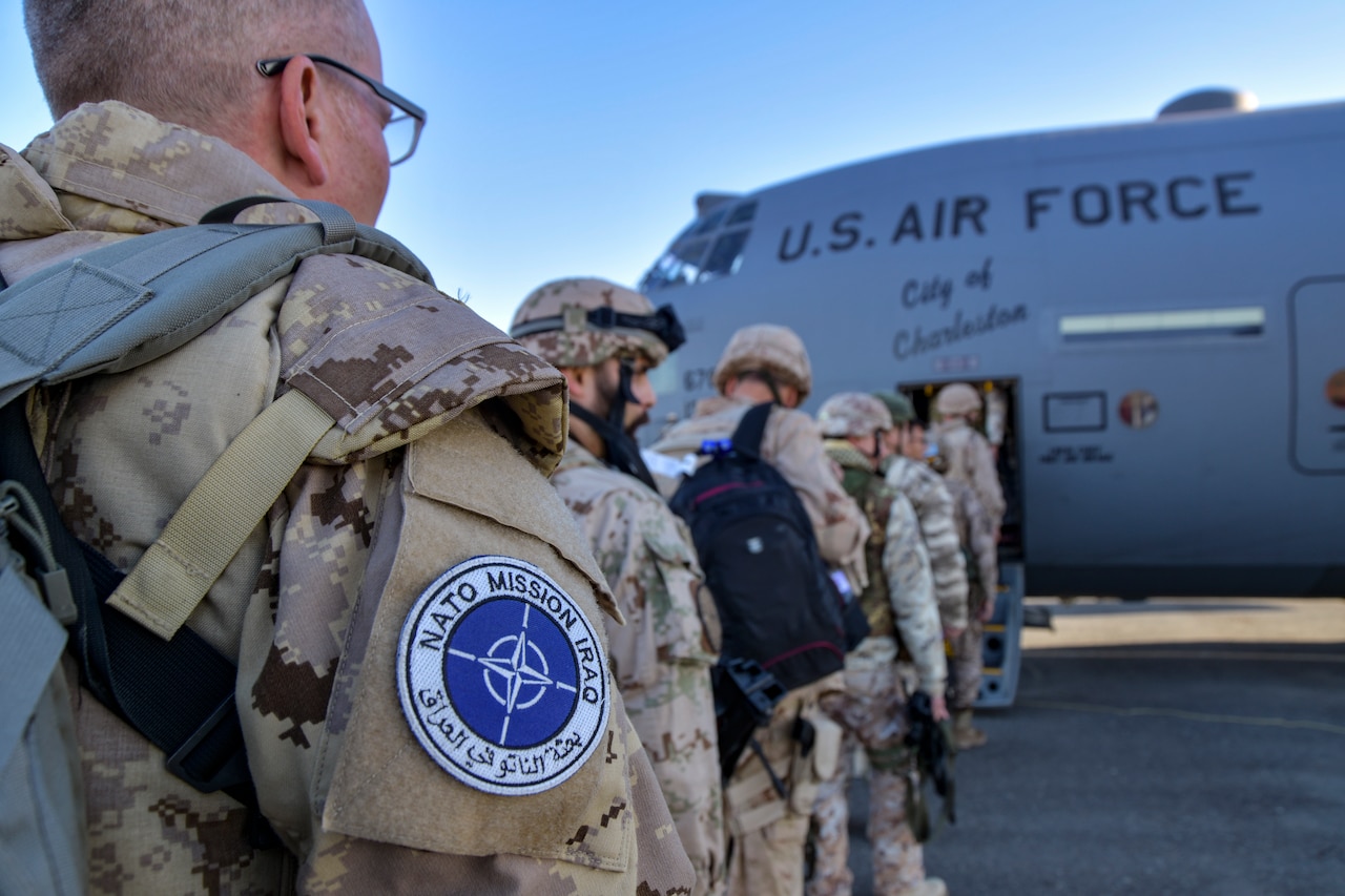 International troops board an Air Force transport plane.