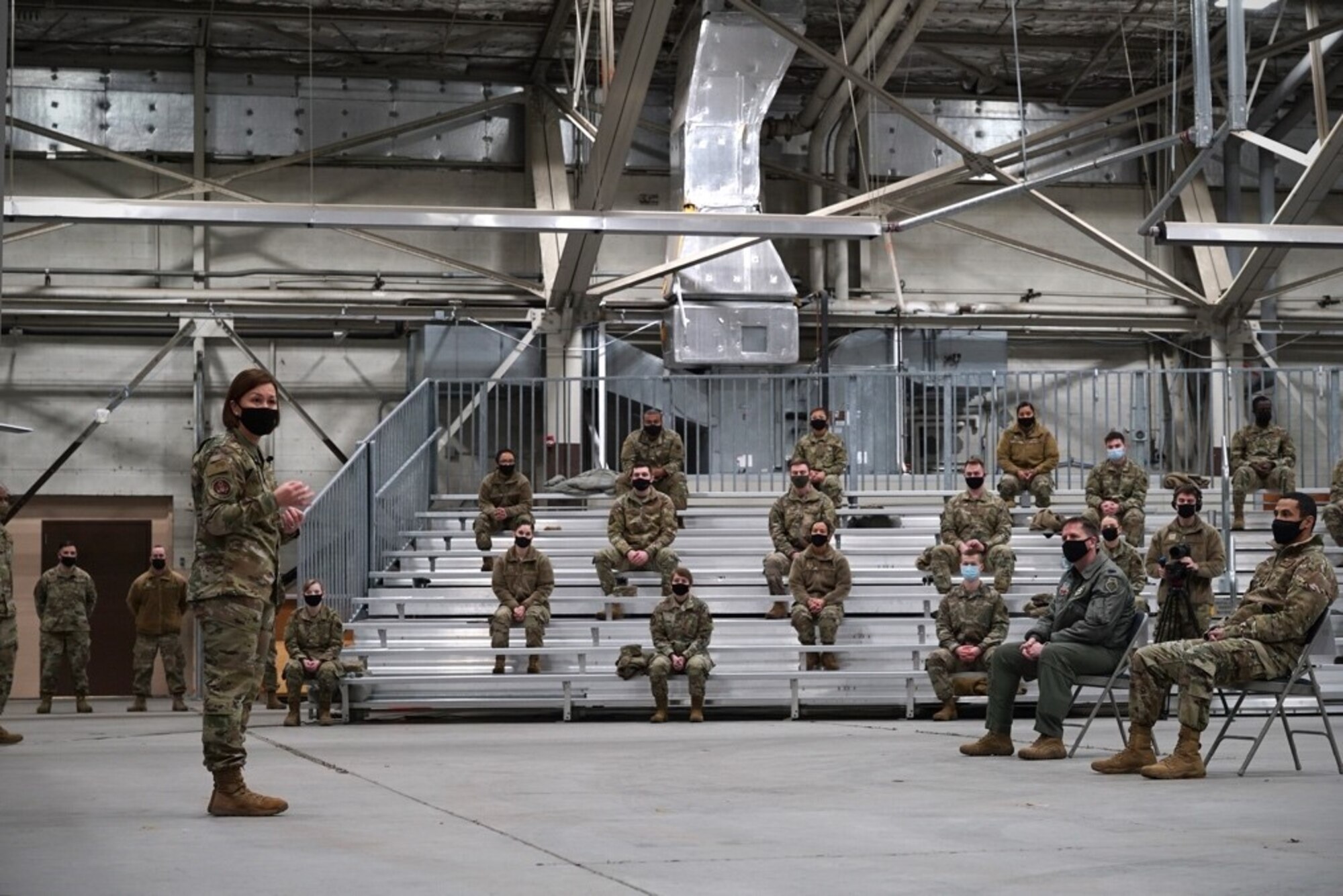 Chief Master Sergeant of the Air Force JoAnne S. Bass stands in front of a crowd of airmen at Grand Forks Air Force Base, N.D. The audience size was limited to abide by current COVID-19 social distancing standards and guidelines – one of the topics of discussion.