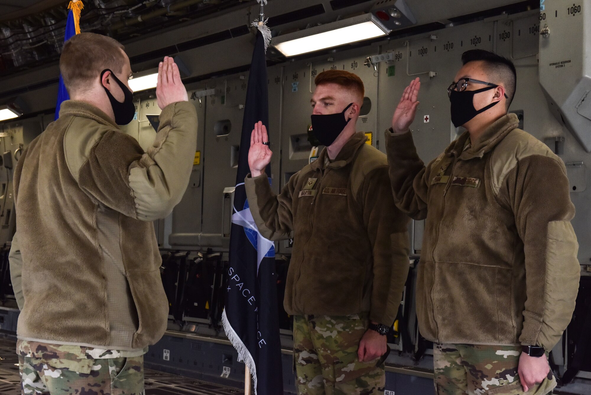 Senior Airman Daniel Martin and Airman 1st Class Hoang Pham from the 87th Communications Squadron recite the Oath of Enlistment during a transfer ceremony at Joint Base McGuire-Dix-Lakehurst, NJ Feb. 12, 2021. Fifteen Airmen across Joint Base MDL volunteered to become Guardians in the U.S. Space Force during February 2021. (U.S. Air Force photo by Senior Airman Shay Stuart)