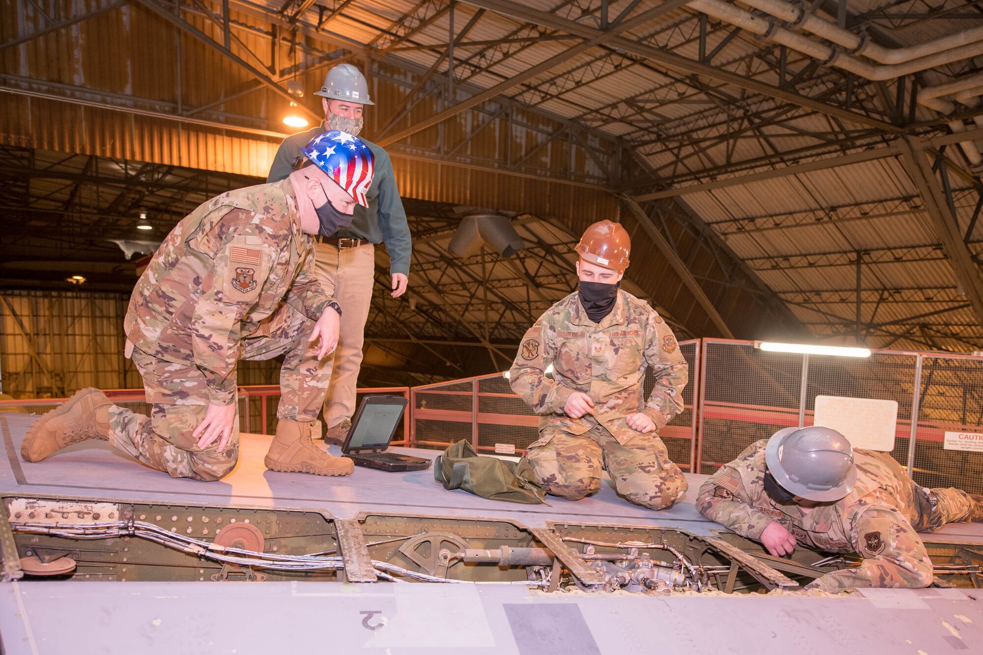 Chief Master Sgt. Chad Bickley, 18th Air Force command chief, greets a pair of Team Dover Airmen from the 436th Maintenance Squadron working on the tail of a C-5M Super Galaxy at Dover Air Force Base, Delaware, Feb. 12, 2021. The ISO dock at Dover AFB is the only maintenance dock in the Air Force capable of performing maintenance steering group-3 major inspections of C-5M aircraft. (U.S. Air Force photo by Mauricio Campino)