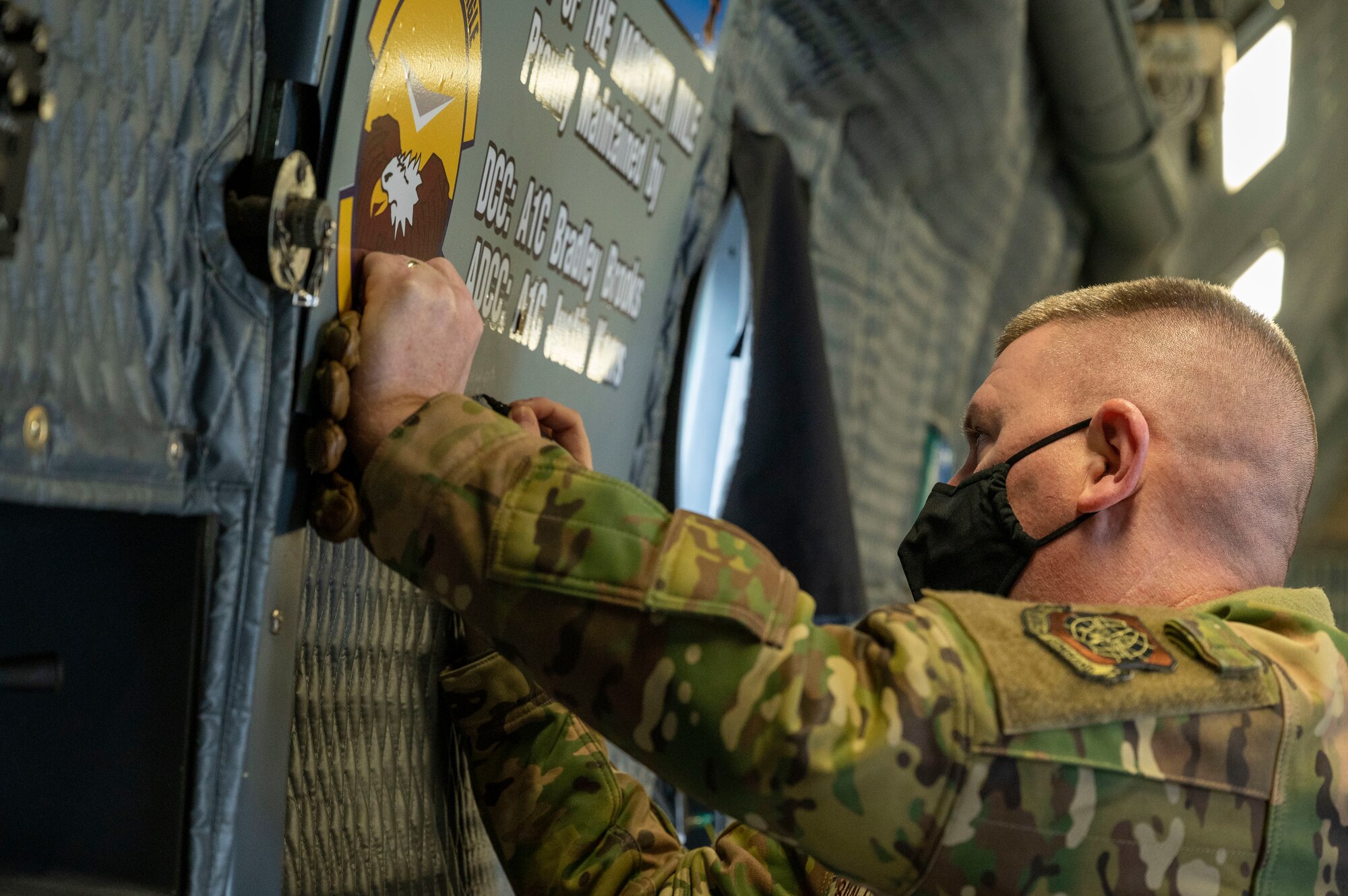 Chief Master Sgt. Chad Bickley, 18th Air Force command chief, signs a dedicated crew chief  plaque during a C-5M Super Galaxy static display walk-through  at Dover Air Force Base, Delaware, Feb. 12, 2021. During his visit, Bickley witnessed how Team Dover contributes to the rapid global airlift mission. (U.S. Air Force photo by Airman 1st Class Cydney Lee)
