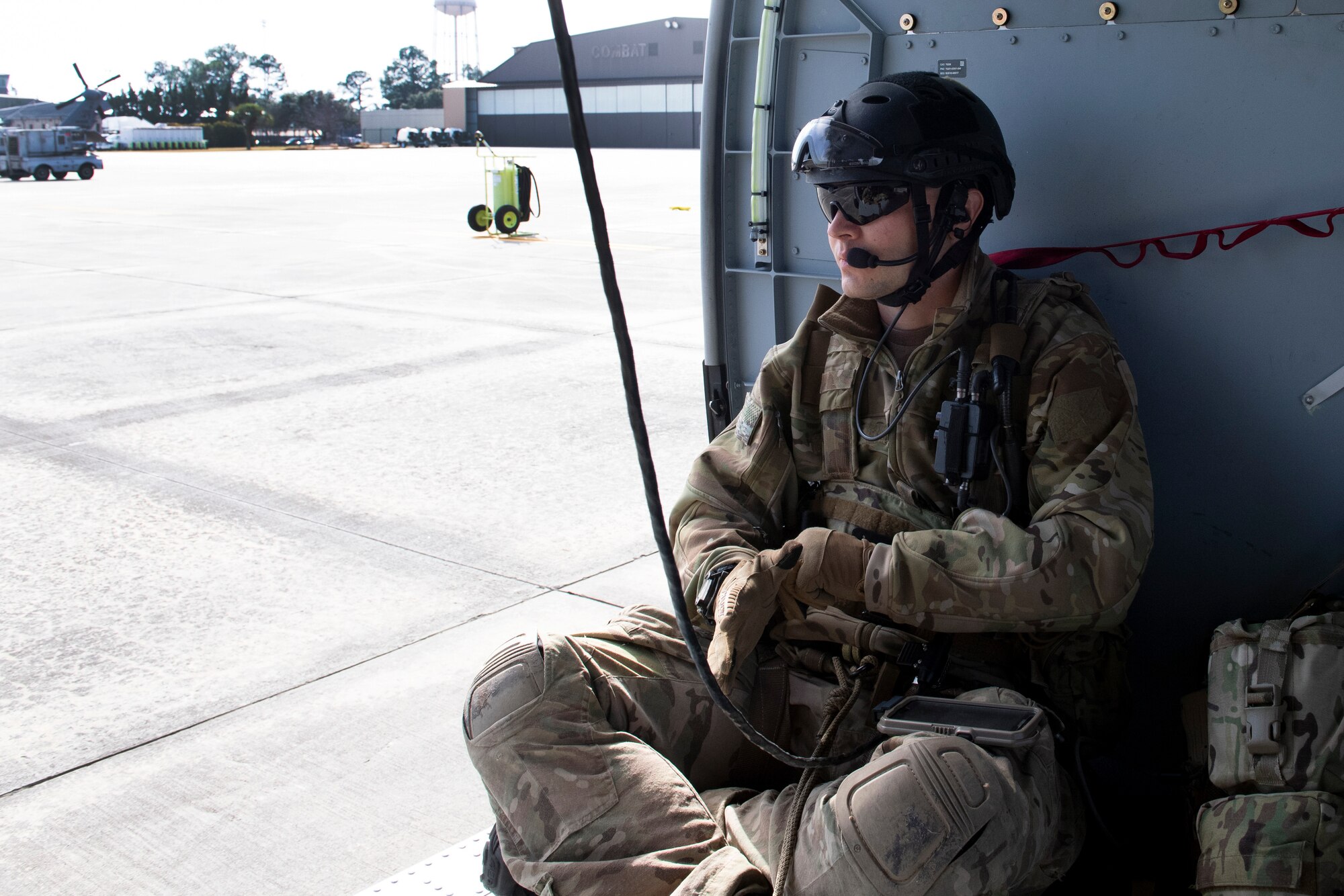 A rescue airman sits in a helicopter before take off.