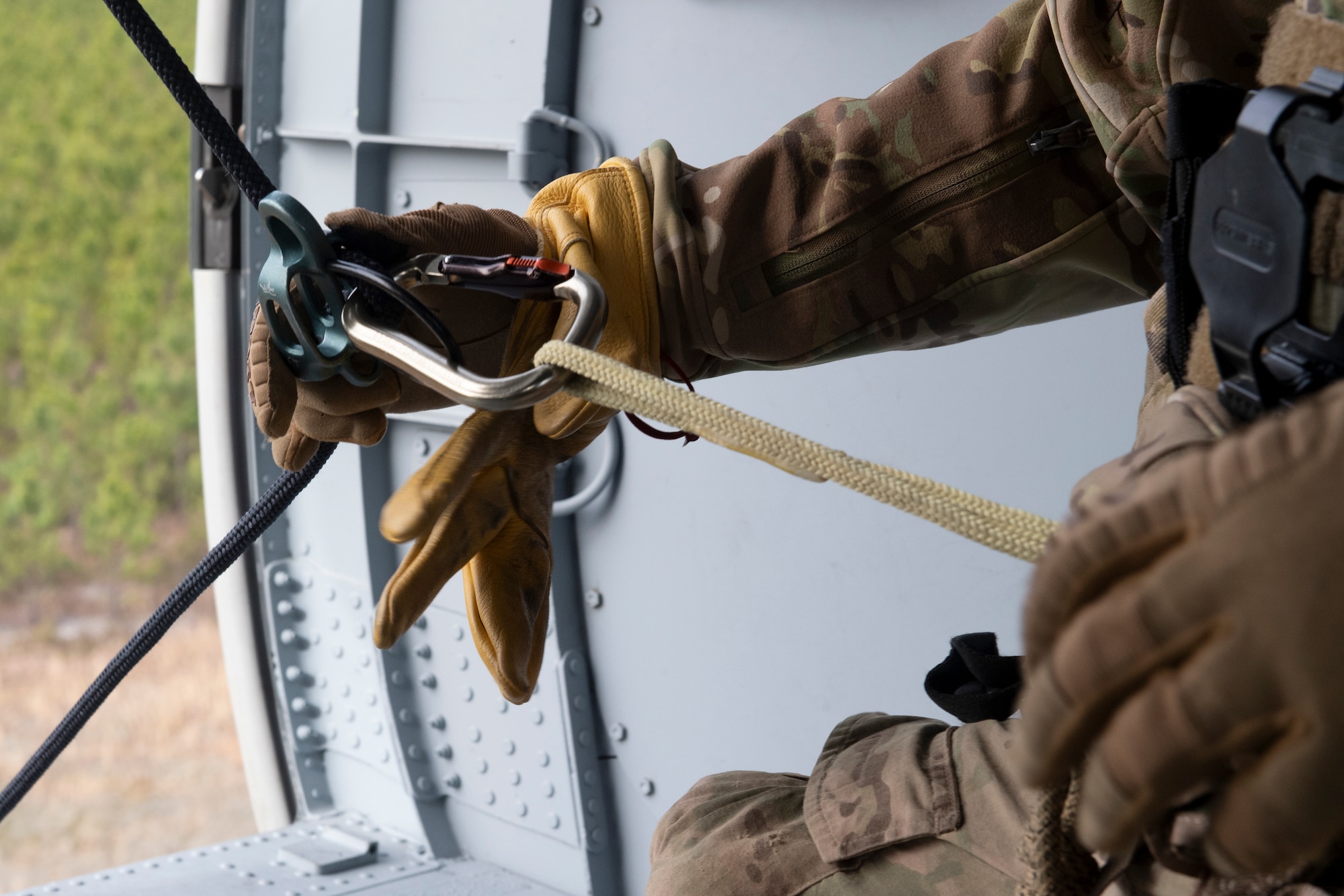 A rescue airman adjusts his rappel line.