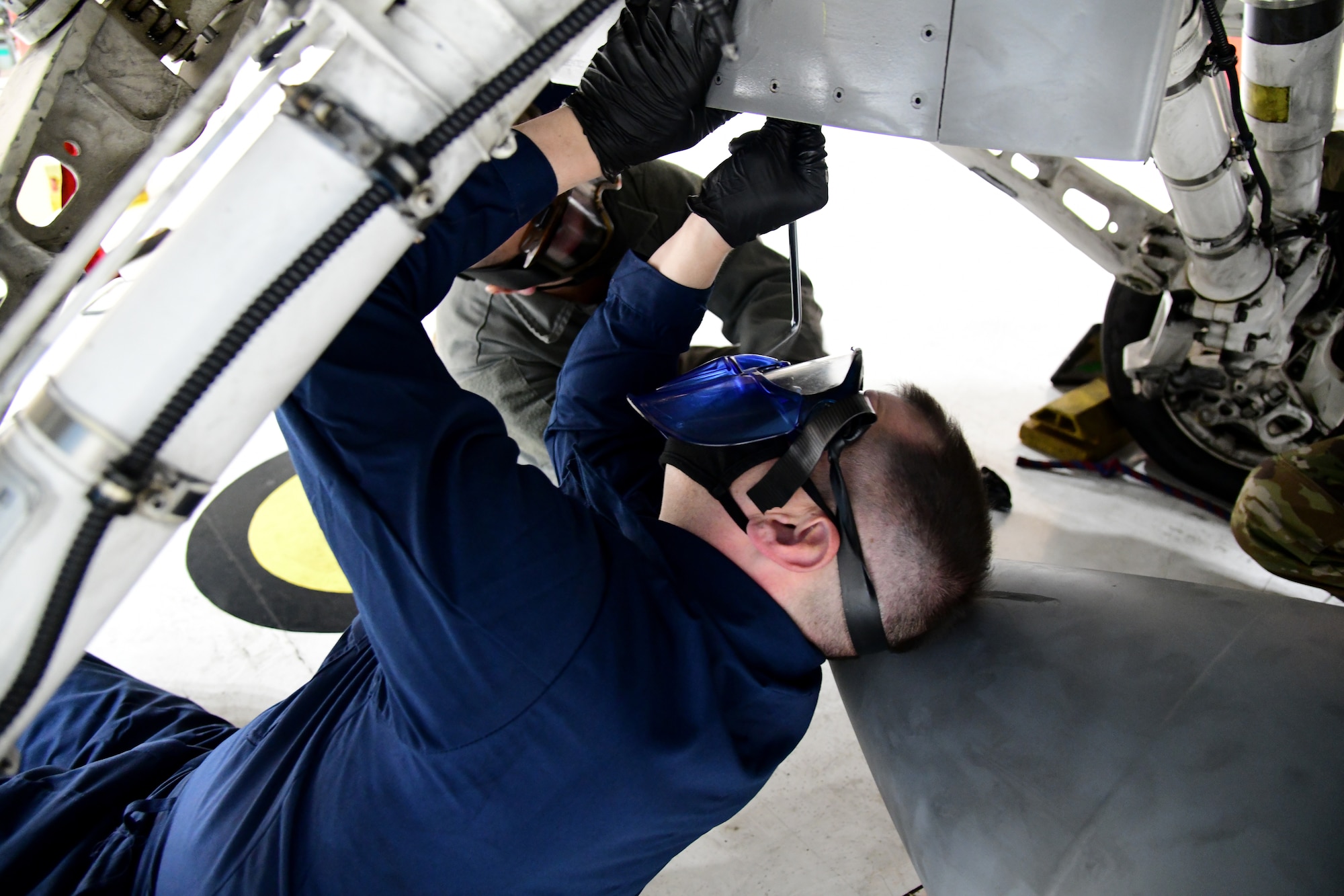 Tech. Sgt. James Whittle, 926th Aircraft Maintenance Squadron, supervises Col. Michael Cabral, 926th Wing Vice commander, as he helps install a 300 gallon center line external fuel tank, Feb. 18, at Nellis Air Force Base, Nevada. Cabral joined the Reserve maintainers as they demonstrated how they utilize Technical Orders to maintain Nellis AFB aircraft.