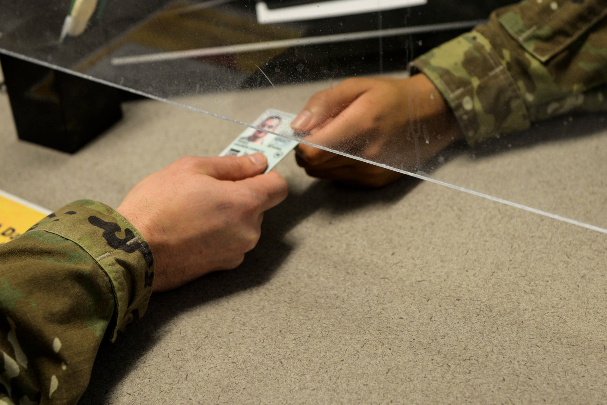 A customer hands his Common Access Card over to a technician for renewal.