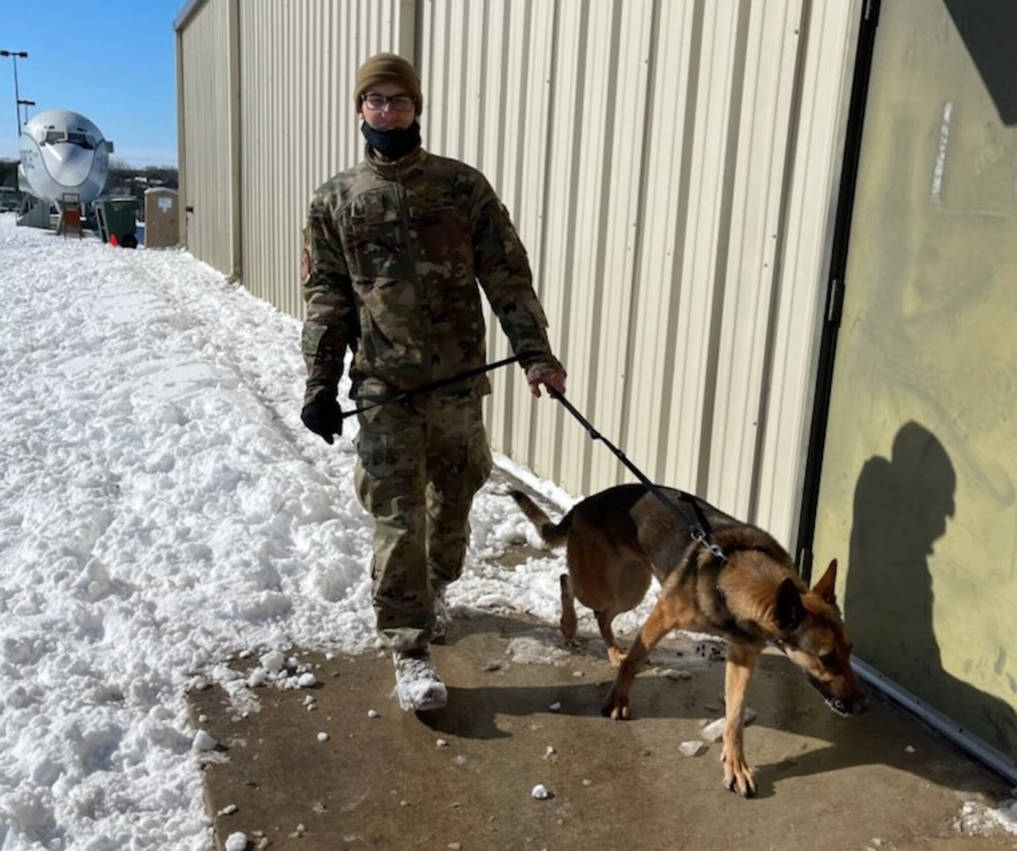 Airman 1st Class Dominic A. Fallon, a student in the Military Working Dog Handlers course, walks one of the dogs being kept warm inside at Joint Base San Antonio-Chapman Training Annex Feb. 15, 2021.