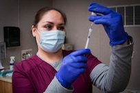 Crystal Tyler, pharmacy technician, prepares an injection for an Operation Warp Speed patient volunteer at Brooke Army Medical Center, Fort Sam Houston, Texas, November 16, 2020. BAMC and Wilford Hall Ambulatory Surgical Center are participating in the Phase III trial to evaluate the vaccine under development by AstraZeneca as part of a national initiative to accelerate the development, production and distribution of COVID-19 vaccines, therapeutics and diagnostics.