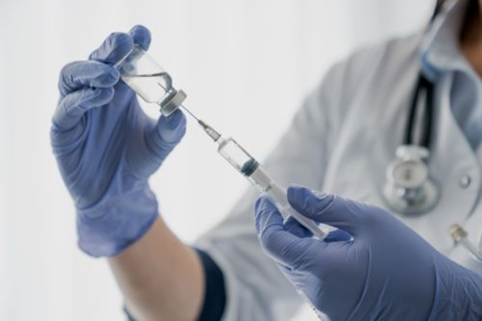 Medical professional filling a syringe with the COVID-19 vaccine.