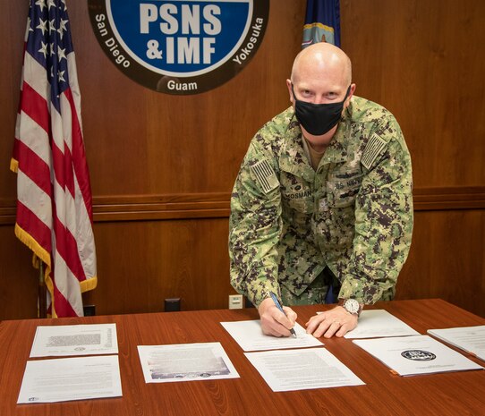 Capt. Jip Mosman, commander, Puget Sound Naval Shipyard & Intermediate Maintenance Facility, signs the application  signaled their commitment to become a Star Site under the Occupational Safety & Health Administration’s Voluntary Protection Program, Feb. 18, 2021, at PSNS & IMF, in Bremerton, Wash.